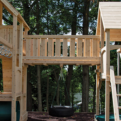 A bridge connecting two cedar swing set forts. 