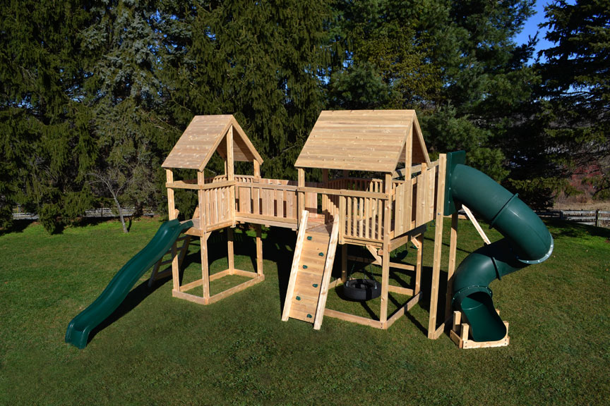Cedar swing sets with two forts connected with a bridge, includes swings and slides.