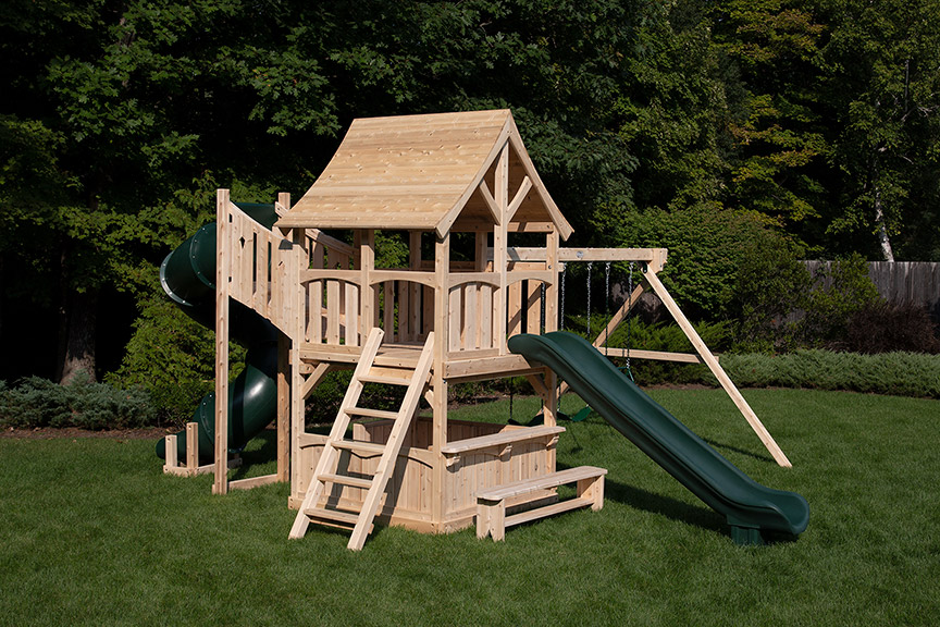Cedar swing set with arched wood roof, tower with green tube slide and ramp.