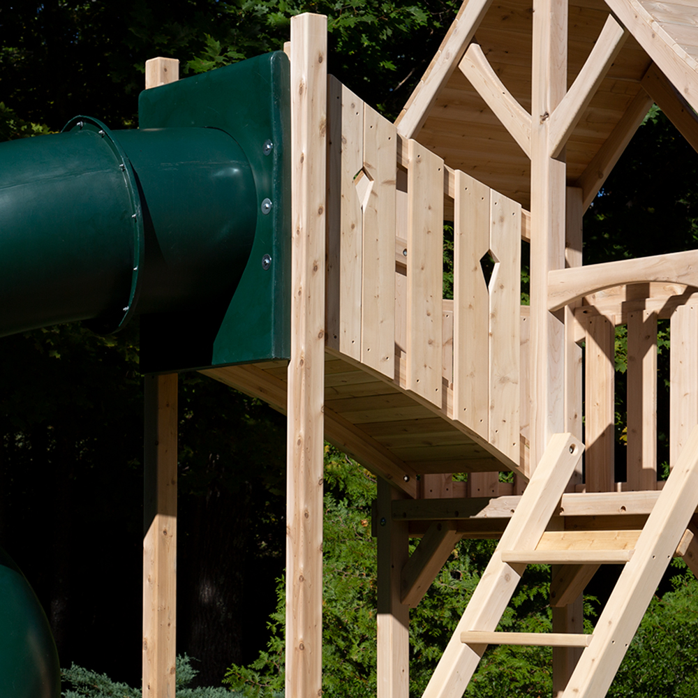 A tower with diamond cut-outs attacted to a cedar swing set fort.