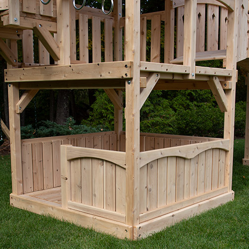 Lower cedar half walls with lower floors under a swing set fort.