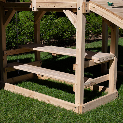 A cedar Picnic table under a playset fort. 