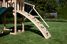 Triumph Play System's havendale climber cedar swing set with rockwall and slide.