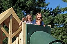 Triumph Play System's Havendale Deluxe cedar swing set with tower and tube slide.