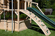 Triumph Play System's Kelton loaded cedar swing set with arched rock wall.