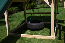 Triumph Play System's Kelton Space Saver Climber cedar swing set 360 degree tire swing.
