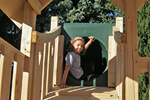 Triumph Play System's Kelton Space Saver Deluxe cedar swing set tube slide entrance.