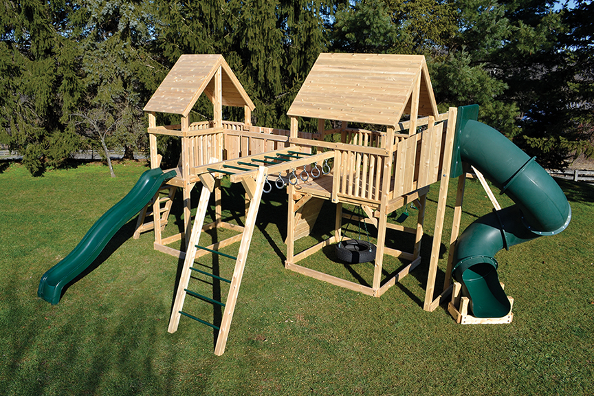 Cedar swing sets with two forts connected with a bridge, includes swings and slides.