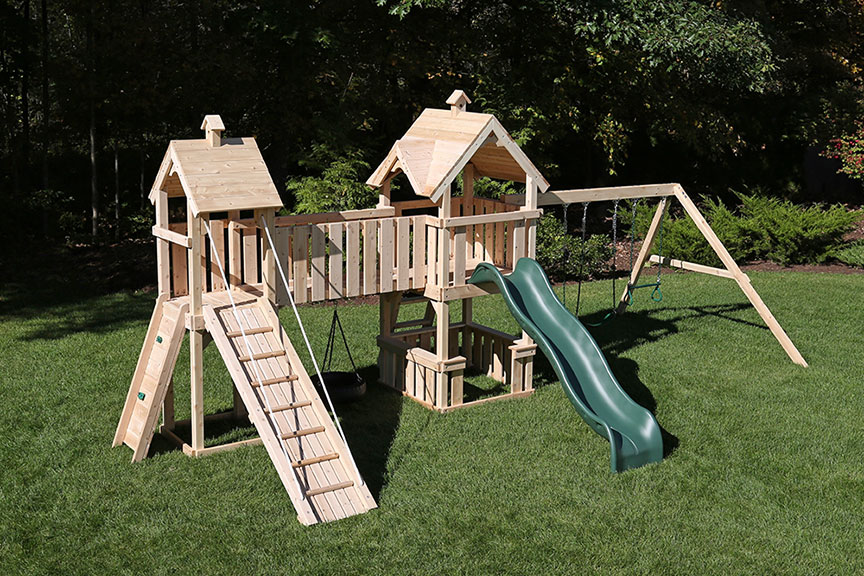 Wooden swing set with two towers and a bridge.