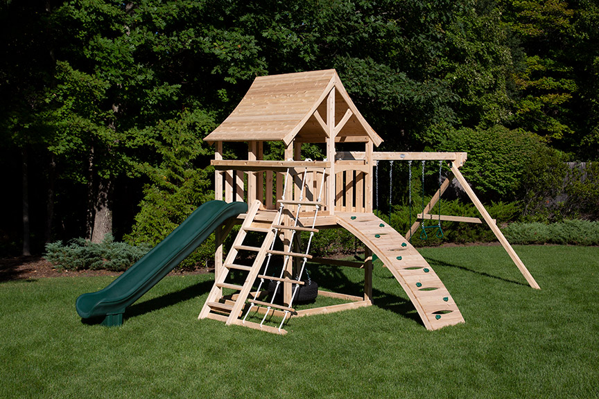 Cedar swing set with arched wood roof, tower with green tube slide and ramp.