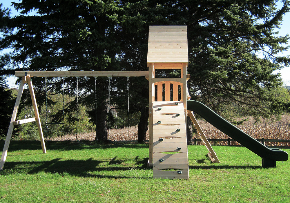 Triumph Play System's havendale climber cedar swing set with rockwall and slide.